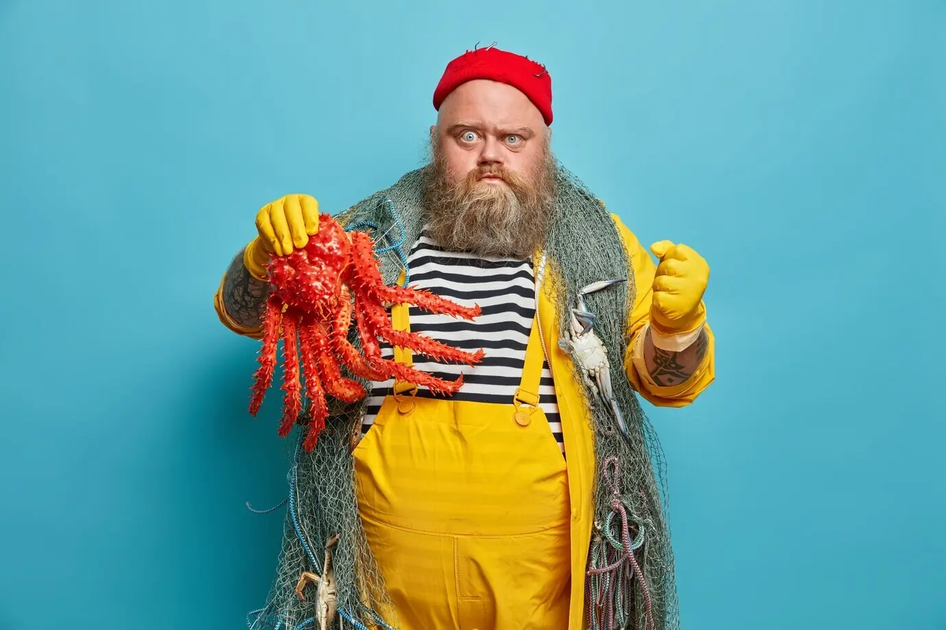 Fettleibiger bärtiger männlicher Seemann mit Fischernetz