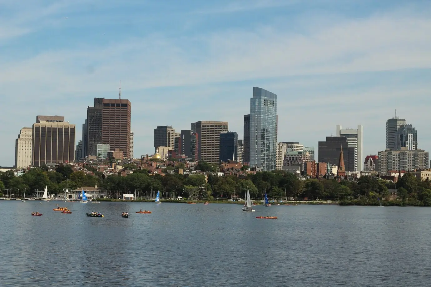 Skyline-Foto von Booten, die an einem sonnigen Tag in der Nähe einer großen Stadt auf dem Wasser segeln.